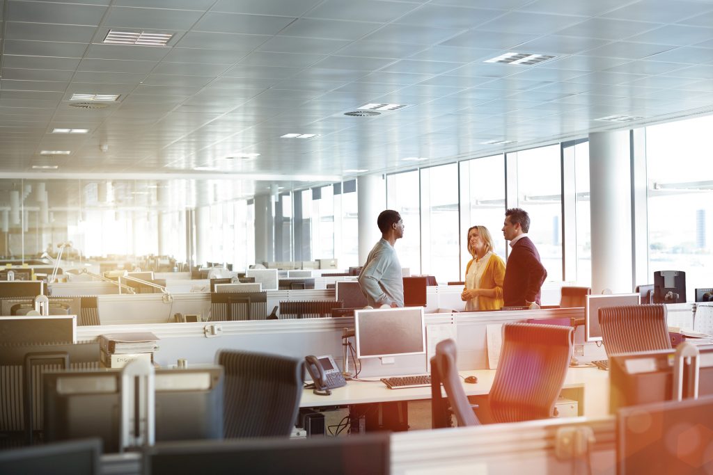 Office space with cubicles and employees talking
