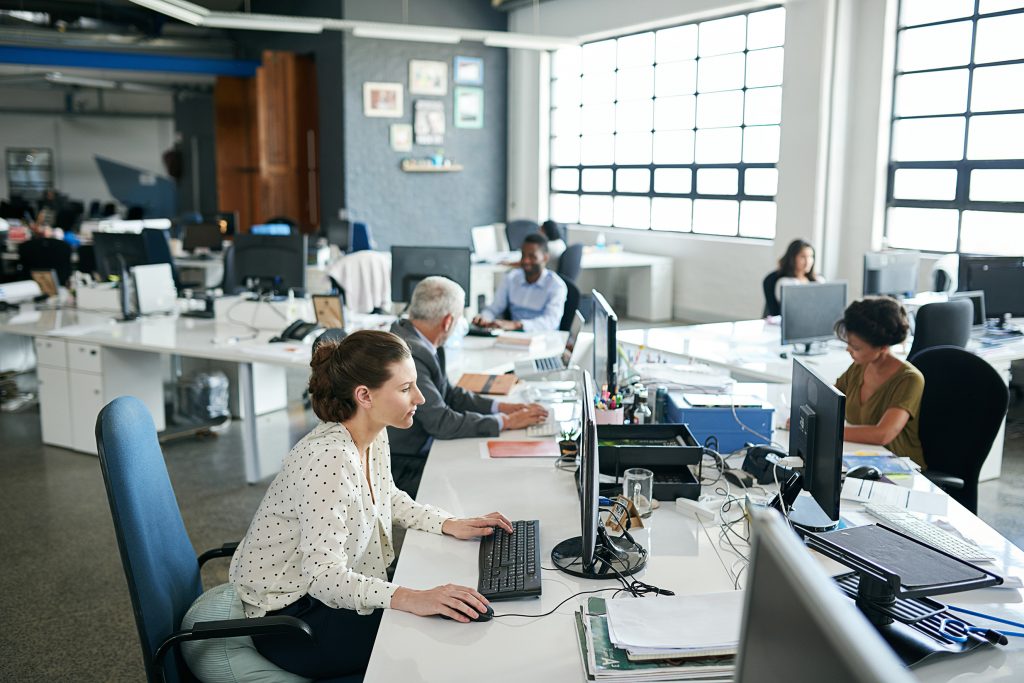 Open workspace with business people working at computers