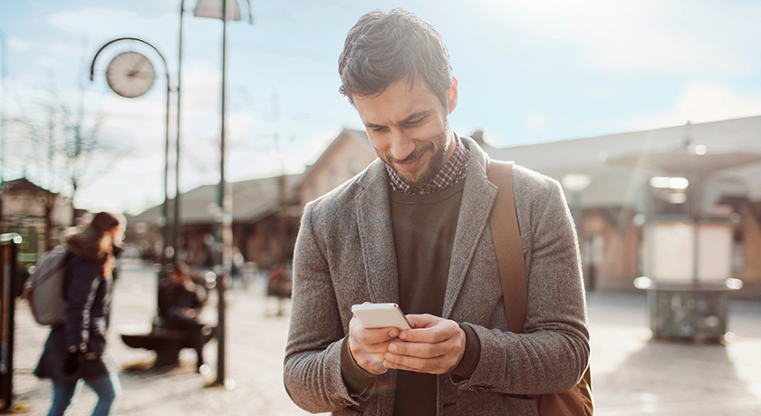 Man reading phone outside