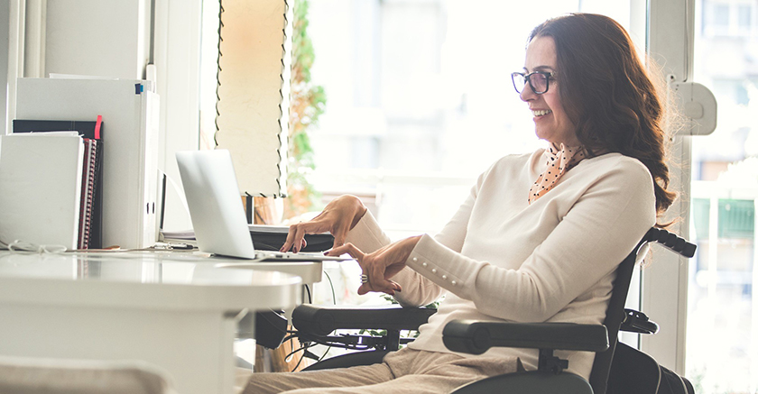 Woman working at desk on laptop.