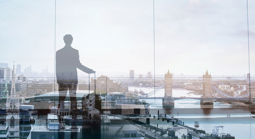 Businessman overlooking London through window