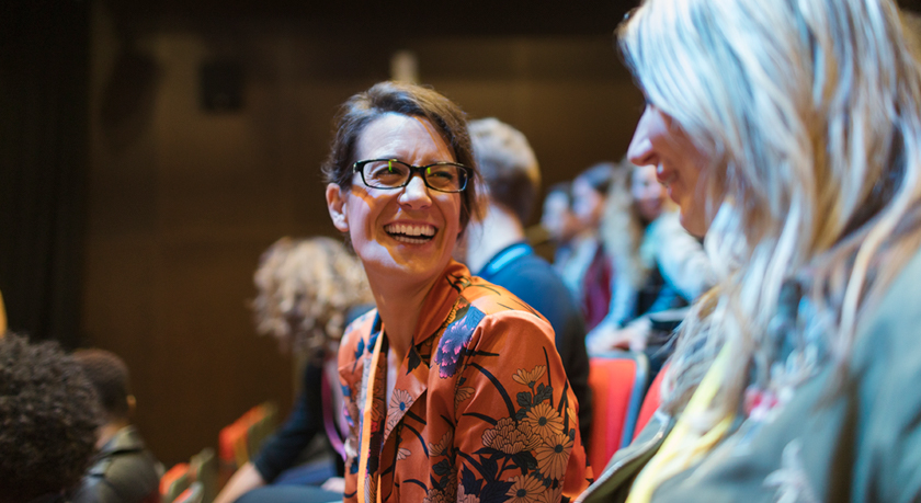 Une femme apprécie une présentation de conférence